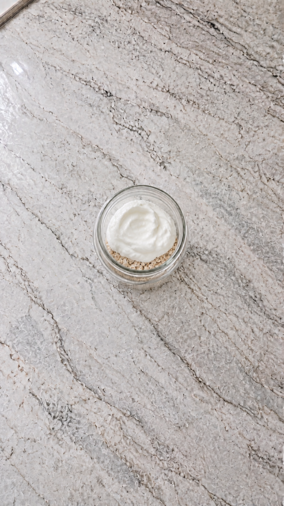 overnight oats set after refrigerating in glass jar on marble countertop
