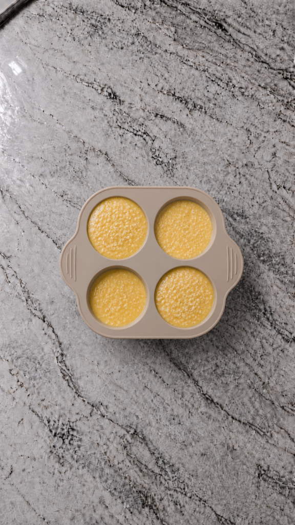 egg mixture poured into silicone muffin mold ready to bake on marble countertop