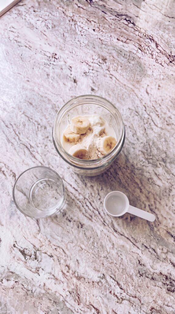 banana slices and protein powder added to blender jar for high protein smoothie