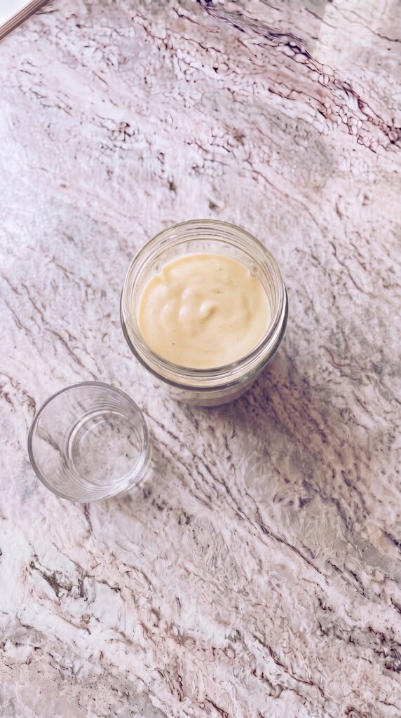 blended high protein smoothie in glass jar ready to pour on marble countertop